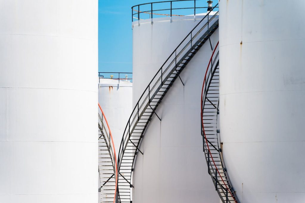 Vertical shot of large steel oil storage tanks with stairs in Antwerp, Belgium.